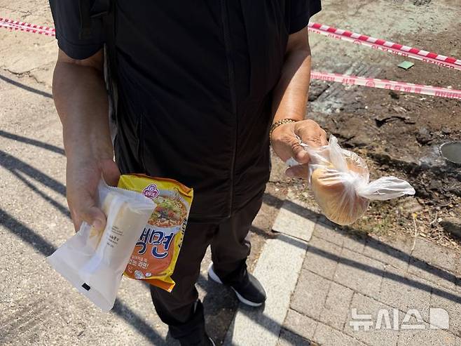 [서울=뉴시스] 추석 연휴를 앞둔 지난 22일 서울 영등포구 무료급식소 '토마스의 집'을 찾은 한 노인이 배식을 마친 뒤 급식소에서 받은 라면과 빵을 들고 있다. 2026.09.25. photo@newsis.com