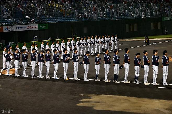 한국 야구 대표팀 선수들이 27일 일본 아이치현 도요하시 시민야구장에서 열린 2026 아이치·나고야 아시안게임 야구 결승 일본과의 경기에 앞서 애국가를 들으며 국민의례를 하고 있다. 도요하시=하상윤 기자