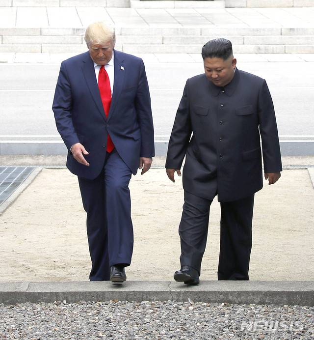 [판문점=뉴시스] 지난 2019년 6월 30일 사진으로, 김정은 북한 국무위원장과 도널드 트럼프 미국 대통령이 판문점 공동경비구역(JSA) 군사분계선을 넘어 북측으로 갔다 다시 남측으로 넘어오고 있다. (사진=뉴시스DB)