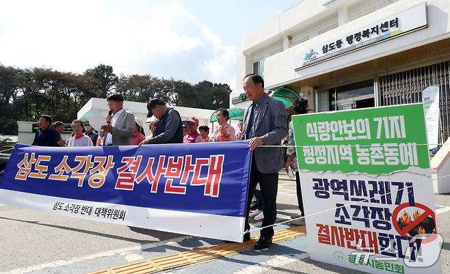 삼도·함평 소각장반대대책위, 전국농민회총연맹 광주시농민회가 30일 오후 전남광주 광산구 삼도동 행정복지센터에서 예정된 자원회수시설 주민설명회를 앞두고 입구를 막은채 설명회 개최 반대를 촉구하고 있다. ⓒ 뉴스1 조수민 기자
