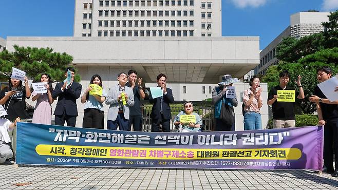 대법원이 영화관에서 시·청각 장애인에게 화면 해설과 자막을 제공해야 한다고 판결한 이달 3일, 전국장애인차별철폐연대 관계자들이 서울 서초구 대법원 앞에서 열린 판결 관련 기자회견에서 박수를 치고 있다. 연합뉴스