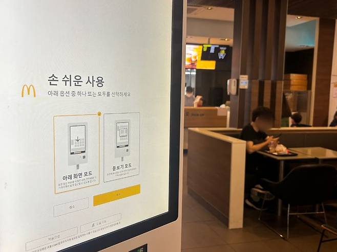 [서울=뉴시스] 장인혜 인턴 기자=29일 서울 명동의 한 프랜차이즈 매장 키오스크 화면에 어르신 등 이용자를 위한 도움 설정 기능을 누르면 두 가지의 손쉬운 사용 모드가 나온다. 2026.09.29. insunn@newsis.com
