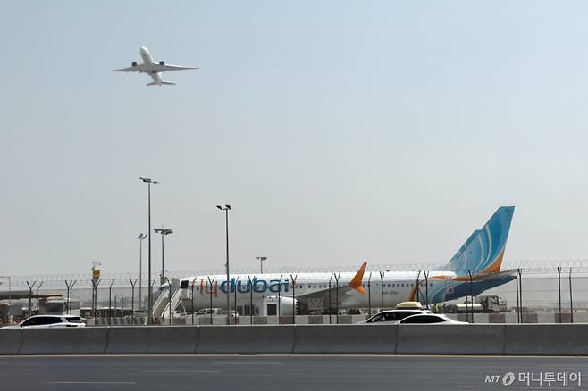 [두바이(아랍에미리트)=AP/뉴시스]아랍에미리트(UAE) 두바이 국제공항에 30일 플라이 두바이 항공기 1대가 착륙해 있는 옆으로 또다른 항공기가 이륙하고 있다. 이날 오전 플라이 두바이 항공기 1대가 이스라엘 텔아비브로 향하던 중 방향을 틀어 사우디아라비아에 착륙한 데 이어 또다른 항공기 1대도 텔아비브로 가던 중 두바이로 회항했다. 2026.09.30. /사진=유세진