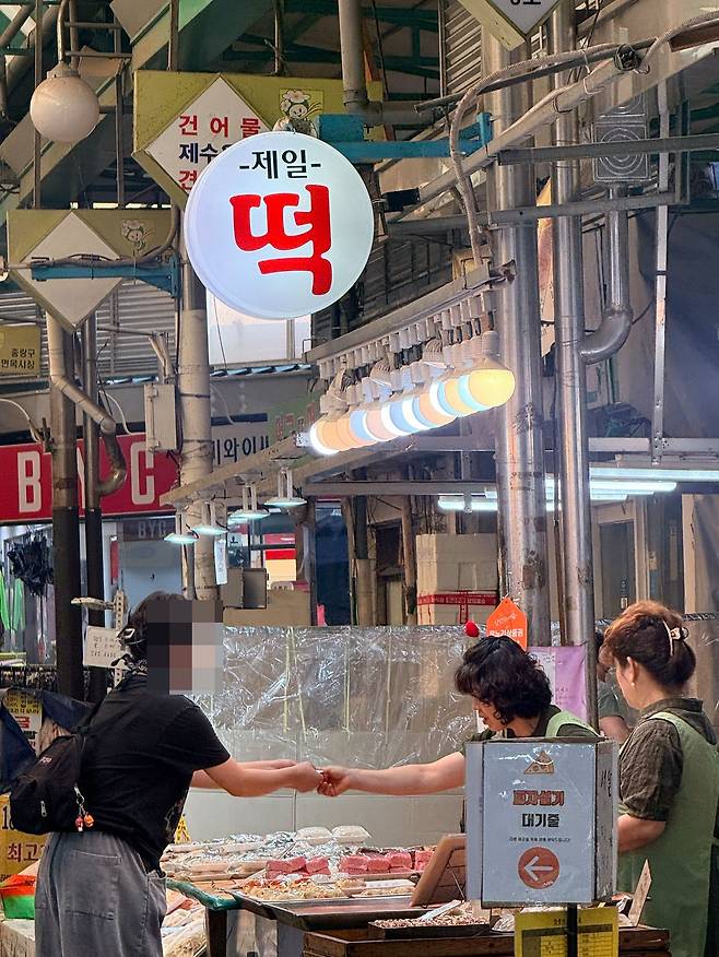 지난달 30일 서울 면목시장 제일떡집에서 손님들이 피자설기를 사고 있다. 백설기에 토마토소스와 치즈, 페퍼로니 등을 올린 피자설기는 최근 숏폼을 타고 인기를 얻으며 여러 지역 떡집으로 확산됐다. SNS를 보고 일부러 찾아온 젊은 손님과 자녀에게 가져가기 위해 여러 개를 사는 중장년층이 함께 눈에 띄었다. 이지영 기자