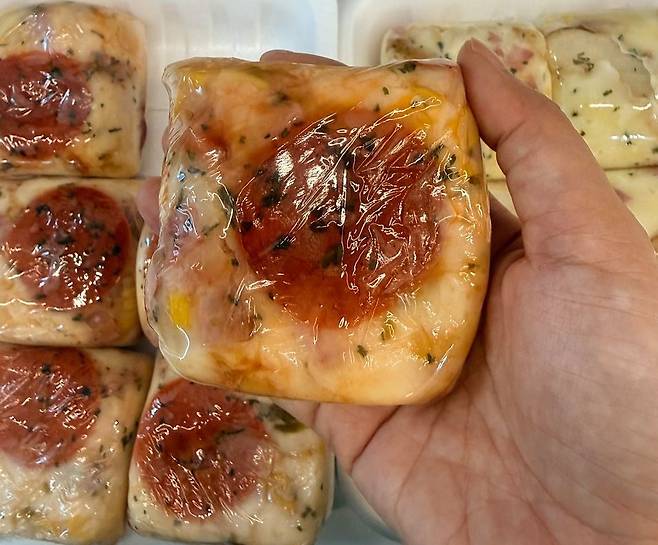 서울 면목시장 제일떡집에서 판매하는 피자설기. 백설기 위에 토마토소스와 치즈, 페퍼로니 등을 얹은 메뉴로, 피자처럼 익숙한 맛에 떡 특유의 쫀득한 식감을 더한 것이 특징이다. 최근에는 동네 떡집에서도 비교적 쉽게 만들어 팔 수 있어 판매처가 빠르게 늘고 있다. 이지영 기자