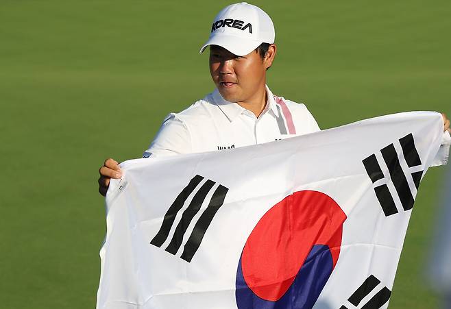 김주형이 3일 일본 아이치현 가스가이 컨트리클럽 동코스에서 열린 2026 아이치·나고야 아시안게임 남자 골프 4라운드에서 우승을 확정지은 뒤 태극기를 들고 기념촬영을 하고 있다. 가스가이/연합뉴스