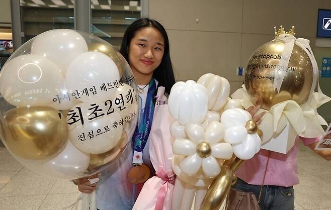 ▲ 아시안게임 배드민턴 여자 단식 사상 첫 2연패를 달성한 배드민턴 '세계 최강' 안세영이 30일 인천국제공항 제2여객터미널을 통해 귀국해 팬으로부터 받은 선물을 들고 기념 촬영을 하고 있다. ⓒ연합뉴스