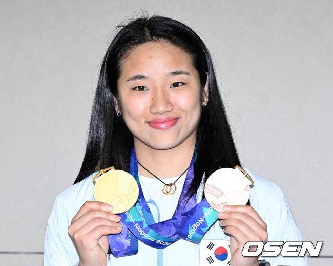 [OSEN=인천공항, 이대선 기자] 2026 아이치-나고야 아시안게임에 참가한 대한민국 배드민턴 대표팀이 30일 인천국제공항을 통해 입국했다.10월 4일까지 45개국·난민팀 등 1만여 명의 선수단이 469개 금메달을 놓고 격돌하는 아시안게임에 참가한 대한민국 선수단은 41개 종목에 1,051명의 선수를 파견해 금메달 40개 이상을 목표로 하고 있다.배드민턴 안세영이 메달을 걸고 포즈를 취하고 있다. 2026.09.30 /sunday@osen.co.kr
