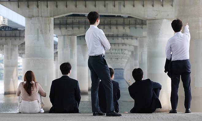 서울 영등포구 여의도한강공원에서 직장인들이 그늘에 앉아 휴식을 취하고 있다. 연합뉴스