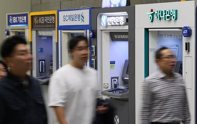 6일 서울 시내 한 건물에 설치된 시중 은행 현금 자동 입출금기(ATM) 앞을 시민들이 지나가고 있다. 뉴시스