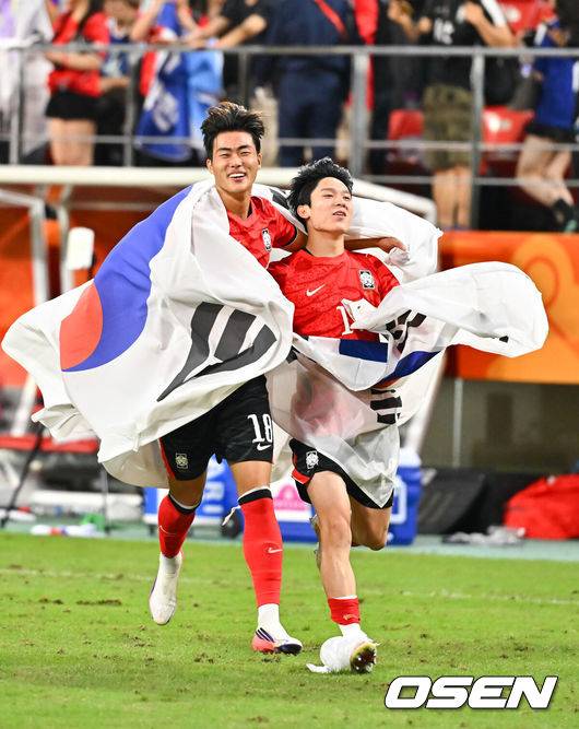 [OSEN=도요타(일본), 박준형 기자] 미쳤다! 엄지성(24, 스완지 시티)이 결승골로 한국축구를 살렸다. 이민성 감독이 이끄는 U23 남자축구대표팀은 3일 오후 7시 30분 도요타 스타디움에서 개최된 아이치-나고야 아시안게임 2026 결승전에서 엄지성의 결승골이 터져 숙적 일본을 1-0으로 제압했다. 경기종료 후 김명준과 양민혁이 태극기를 들고 그라운드를 돌고 있다.   2026.10.03 /  soul1014@osen.co.kr