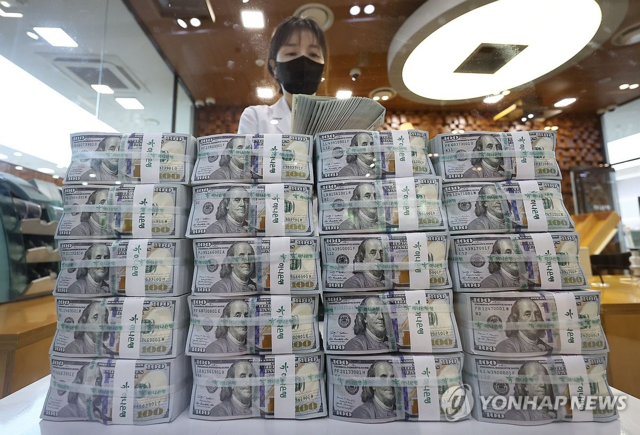 서울의 한 은행에서 직원이 달러화를 정리하고 있다. 정부는 국경 간 가상자산 이전 내역을 한국은행 외환 전산망에 보고하도록 하고, 국세청·관세청·금융감독원·금융정보분석원과 정보를 공유해 불법 외환거래 감시를 강화할 방침이다. [연합뉴스]