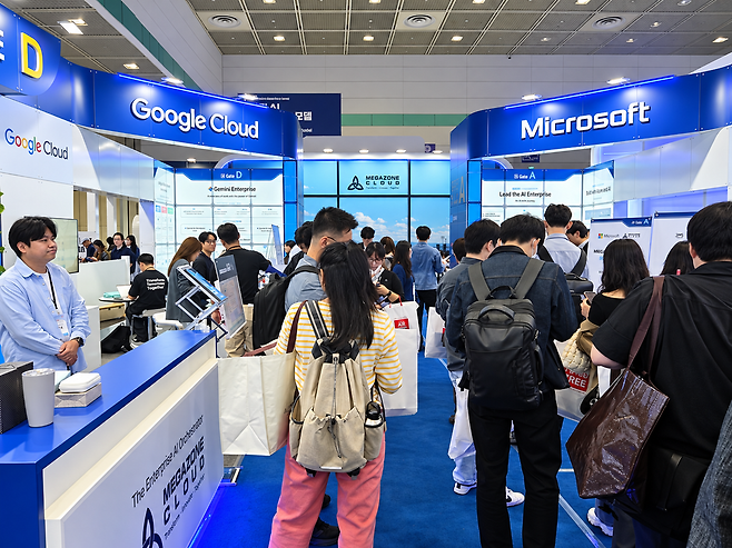7일 서울 코엑스 'AI 페스타 26' 메가존클라우드 공동 전시공간에서 참관객들이 구글클라우드와 마이크로소프트의 기업용 AI·클라우드 기술을 살펴보고 있다. /전시현 기자&nbsp;