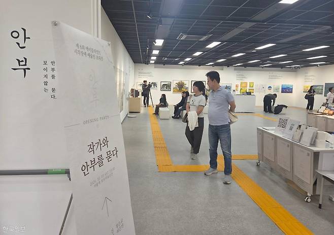 3일 서울 중구 서울스퀘어 별관 모두미술공간에서 관람객들이 시각장애 예술가 6인의 전시 '안부-보이지 않는 안부를 묻다'를 둘러보고 있다. 전시장 바닥에는 시각장애 관람객을 위해 관람 동선을 안내하는 점형·선형 유도블록이 설치돼 있다. 나민서 기자