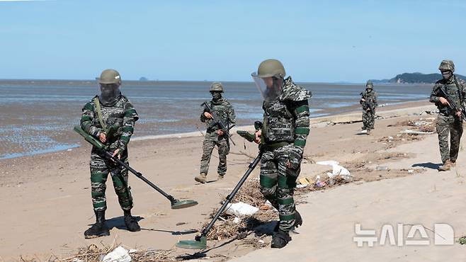 [인천=뉴시스] 전진환 기자 = 해병대 제2사단 장병들이 12일 인천시 강화군 서도면 뒷장술해수욕장에서 유실지뢰 탐지를 하고 있다. 지난달 말 집중호우로 유실된 것으로 추정되는 북한 유실지뢰가 인천 강화군 일대 해안에서 잇따라 발견되고 있다. 2026.08.12. amin2@newsis.com
