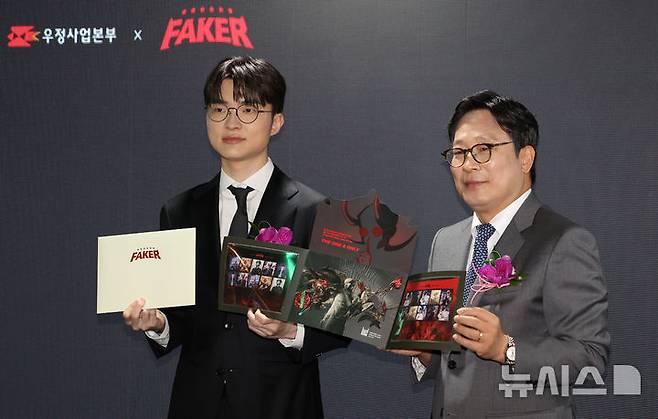 [서울=뉴시스] 김선웅 기자 = e스포츠 리그 오브 레전드 '페이커' 이상혁 선수와 박인환 우정사업본부장이 10일 서울 중구 서울중앙우체국 우표박물관에서 열린 페이커 기념우표 기획전시관 개관식에서 오는 23일 발매하는 페이커 기념우표를 선보이고 있다. 2026.10.10. mangusta@newsis.com