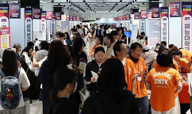 지난달 18일 서울 강남구 코엑스에서 열린 2027학년도 전문대학 수시 입학정보박람회에서 학생들이 부스를 둘러보고 있다. 연합뉴스