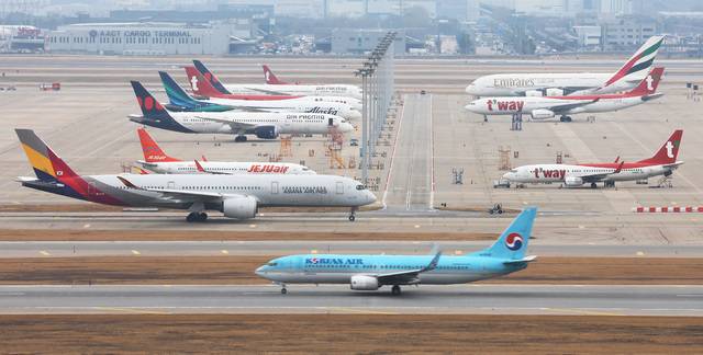 공항 계류장에 항공기들이 대기하고 있는 가운데, 대한항공 항공기가 활주로로 이동하고 있다. 연합뉴스