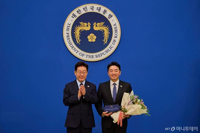 [서울=뉴시스] 김진아 기자 = 이재명 대통령이 15일 청와대에서 강훈식 전 비서실장에게 공로패를 수여, 기념촬영을 하고 있다. (사진=청와대 제공) 2026.10.15. photo@newsis.com *재판매 및 DB 금지 /사진=김진아