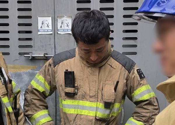 16일 경기 부천의 한 금속부품 도장 공장에서 화재 진압을 마친 소방대원이 동료 소방관의 심각한 부상 소식에 눈물을 흘리고 있다. 2026.10.16 /연합뉴스