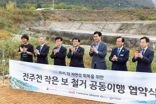 김성환 기후에너지환경부 장관(가운데)이 19일 전북 완주군 소재 전주천 상죽음보 일원에서 전주천 작은 보 철거를 위한 공동이행 협약을 체결하고 기념촬영을 하고 있다. 사진=기후에너지환경부 제공