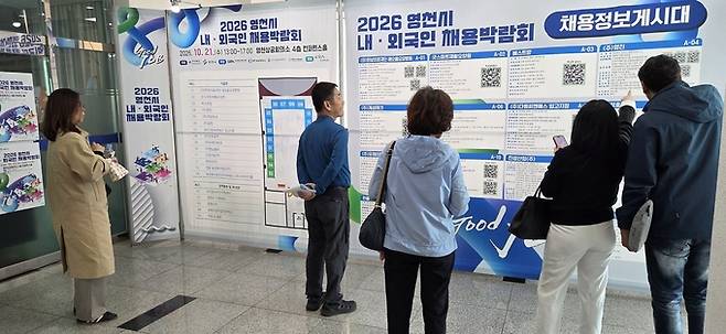 ▲ 시민, 외국인 등 구직자들이 2026 영천시 내·외국인 채용박람회장의 채용정보게시대를 보고 있다. 권오석 기자