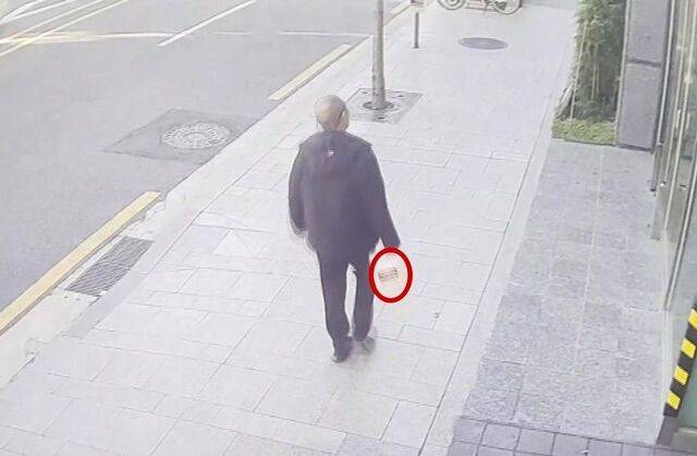 20일 방화 혐의로 체포된 70대 남성 A씨가 화재 발생 전 인화 물질로 추정되는 물건을 들고 서울 강남구 역삼동의 한 건물을 향해 이동하는 모습. 연합뉴스