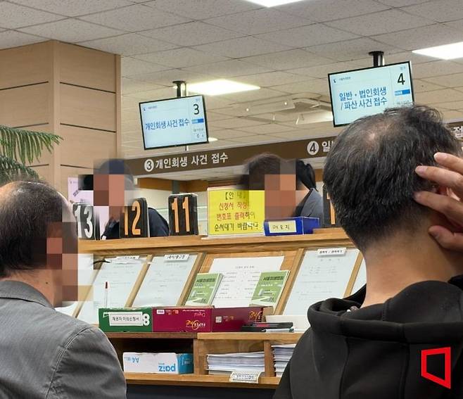 지난 20일 서울 서초동 서울회생법원 1층 접수실에서 채무자들이 개인회생 및 파산 신청 서류를 제출하기 위해 차례를 기다리고 있다. 박호수 기자