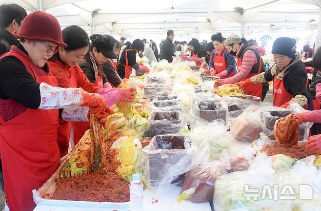 [전주=뉴시스] 김얼 기자 = '제7회 2025 전주김장문화축제'가 열린 22일 전북 전주시 전주월드컵경기장을 찾은 시민들이 김장을 담그고 있다. 2025.11.22. pmkeul@newsis.com