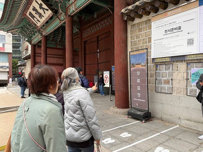 29일 서울 중구 덕수궁 대한문 앞 관광객들이 무료 입장 안내문을 보고 있다. /현정민 기자