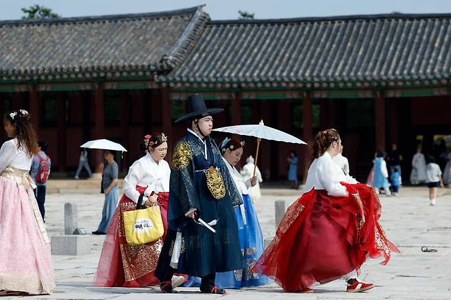 지난 12일 외국인 관광객들이 서울시 종로구 경복궁에서 렌탈 한복을 입고 궁궐을 거닐며 추억을 남기고 있다. /뉴스1