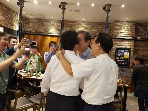 바른정당 김무성 의원(가운데)과 유승민 의원이 10일 의원단 만찬에서 입맞춤을 하고 있다. [바른정당 제공]