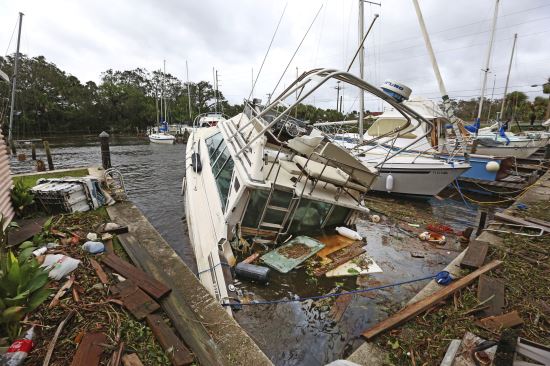 (올렌도 센티넬/AP뉴시스) 11일(현지시간) 플로리다주 팜 쇼어스에서 물에 잠긴 보트가 잔해에 둘러싸여 있다.