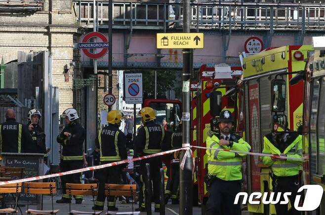 지난 15일 영국 런던 파슨스 그린' 지하철역에 정차해 있던 지하철에서 폭발물이 터져  소방관과 경찰들이 수습하고 있다.