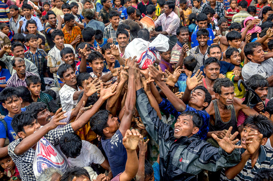미얀마 정부의 탄압을 피해 방글라데시로 피난한 로힝야족 난민들이 발룩칼리 난민캠프에서 구호품을 받기 위해 손을 뻗고 있다. 방글라데시로 피한 이들은 40만 명을 넘어섰다. [AP=연합뉴스]