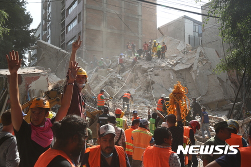 【멕시코시티=AP/뉴시스】멕시코 수도 멕시코시티에서 19일(현지시간) 규모 7.1의 강진으로 건물이 무너진 가운데 자원봉사자들과 군인들이 생존자 수색작업을 하고 있다.  2017.09.20
