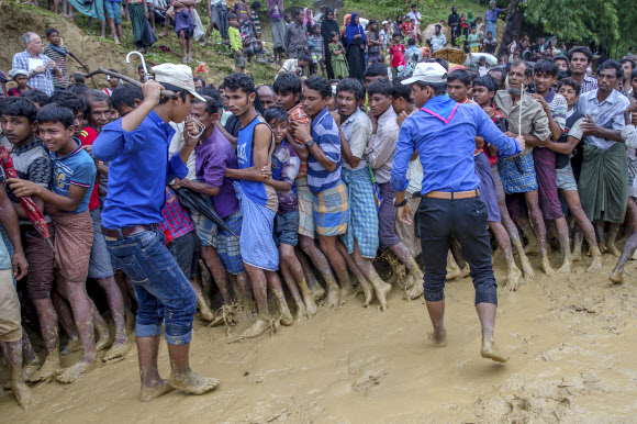 19일 방글라데시 쿠투팔롱 난민캠프에서 방글라데시인들이 배식을 기다리는 로힝야족 난민들을 쇠갈고리로 위협하며 통제하고 있는 모습.쿠투팔롱 AP 연합뉴스