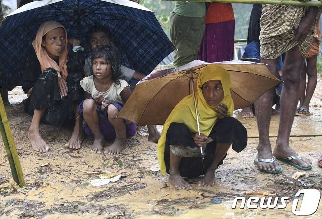 17일(현지시간) 방글라데시와 미얀마 국경지대에 위치한 난민 캠프에서 로힝야족들이 비를 피하고 있다. © AFP=뉴스1