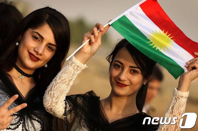 21일(현지시간) 이란 쿠르드계 소녀들이 쿠르드 깃발을 들고 독립투표를 지지하고 있다. © AFP=뉴스1