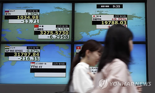 (도쿄 AP=연합뉴스) 도쿄의 한 증권사 앞에서 두 여성이 아시아 각국의 주식시장 주요 지수를 가리키는 전광판 옆을 지나고 있다.      bulls@yna.co.kr