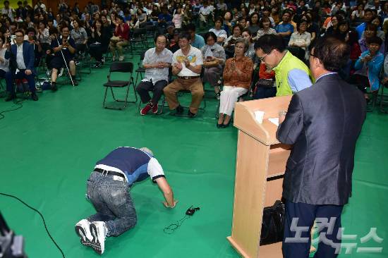 지난 5일 오후 서울 강서구 탑산초등학교에서 열린 강서지역 특수학교 설립 교육감-주민토론회에서 장애 아이를 둔 지역주민이 특수학교설립을 반대하는 주민들을 향해 큰절을 하고 있다. (사진=윤창원 기자)