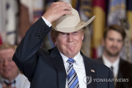 도널드 트럼프 미국 대통령이 지난 7월 17일(현지시간) 백악관에서 '메이드인 아메리카' 주간을 선포하고 카우보이 모자를 쓰는 모습. [EPA=연합뉴스]