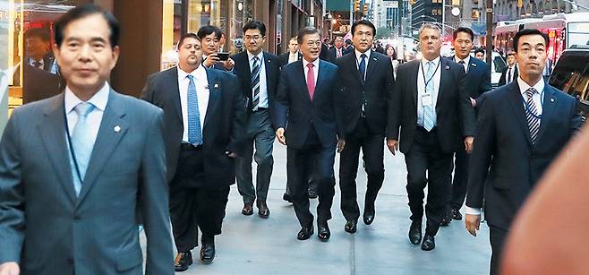 문재인 대통령이 지난 18일 미국 뉴욕 거리를 걸어가고 있다. 문 대통령 경호는 한·미 요원이 함께 수행했는데 미국 경호원 2명(왼쪽에서 둘째와 일곱째)은 양복 상의 단추를 푼 반면 주영훈(맨 왼쪽) 경호처장을 비롯해 한국 경호원들은 단추를 채우고 있다. 외국 대통령 경호원은 위급 상황에서 쉽게 총을 꺼내기 위해 대개 양복 상의 단추를 풀고 있다./청와대