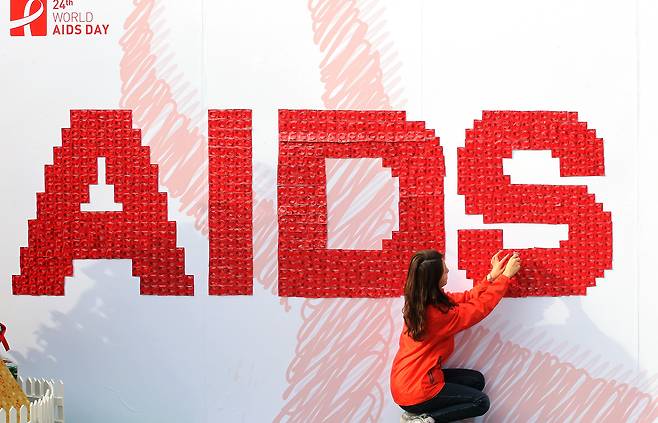 한국에이즈퇴치연맹 관계자가 에이즈 예방을 위한 퍼포먼스 차원에서 붉은 콘돔으로 `AIDS' 영문 글자를 만들고 있다. [연합뉴스]