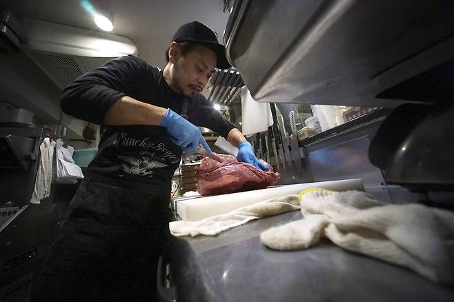 유타카 야나기사와 ‘만찌즈 바가’ 대표가 햄버거 패티를 만들기 위해 미국산 소고기 덩어리를 직접 칼로 해체하고 있다. [AP=연합뉴스]