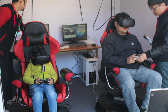 VR 메카닉 액션 게임 ‘프로젝트X’를 체험 중인 가족 관람객.