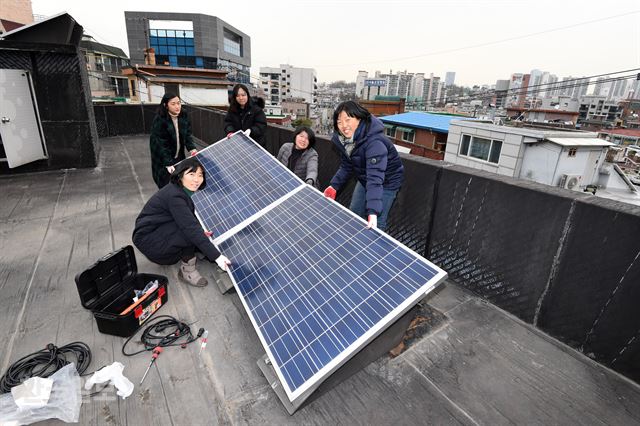 서울 동작구 성대골마을의 리빙랩 연구원들이 20일 마을 내 에너지 슈퍼마켓 옥상에 미니 태양광 발전기를 설치하고 있다. 신상순 선임기자