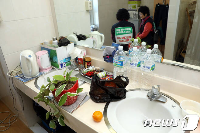 샤워실 구석 의자에 않아 쉬고 있는 충청대 청소 노동자들. © News1 김용빈 기자