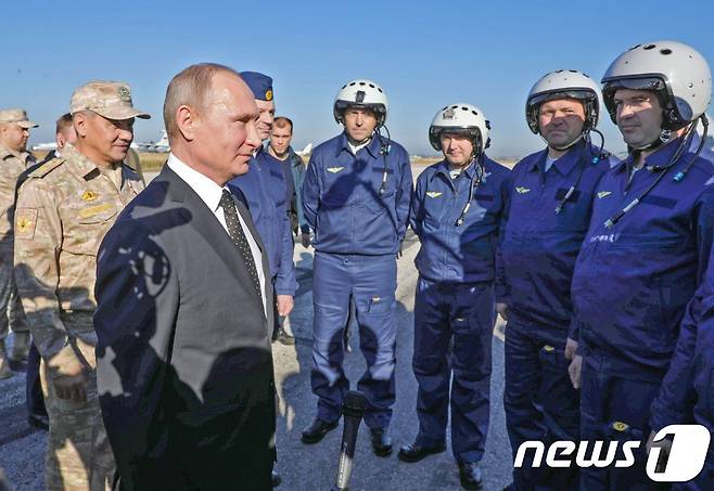 11일(현지시간) 오전 시리아의 러시아 공군기지를 방문한 블라디미르 푸틴 러시아 대통령(왼쪽).© AFP=뉴스1