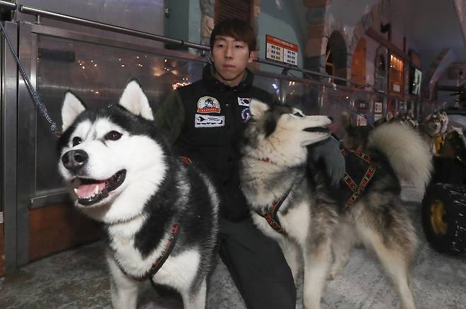 남기정 머셔(Musher.썰매를 끄는 사람)가 11일 경기도 일산 원마운트 스노우파크에서 달리기를 마친 개들을 안아주고 있다. 임현동 기자